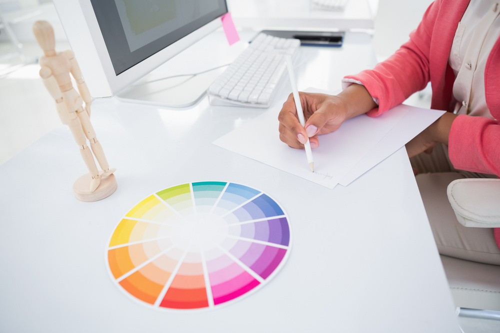 Casual graphic designer working at her desk sketching in her office